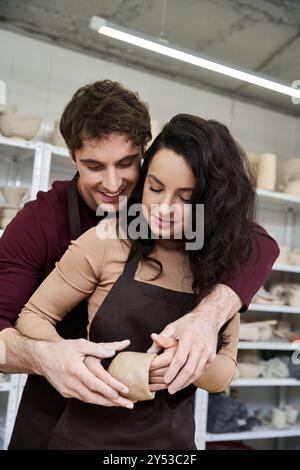 Ein Paar formt fröhlich Ton zusammen und genießt ihre künstlerische Reise. Stockfoto