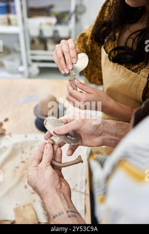 Ein Paar bastelt Töpferwaren und teilt Lachen und Kreativität in einem hellen Studio. Stockfoto