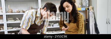 Ein Paar bastelt fröhlich Töpferwaren, die in einem modernen Studio in Kreativität eingetaucht sind. Stockfoto