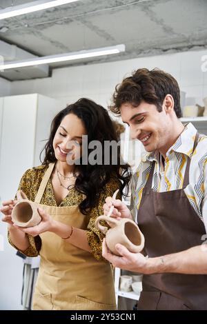 Ein Paar formt fröhlich Ton in schöne Töpferei zusammen. Stockfoto