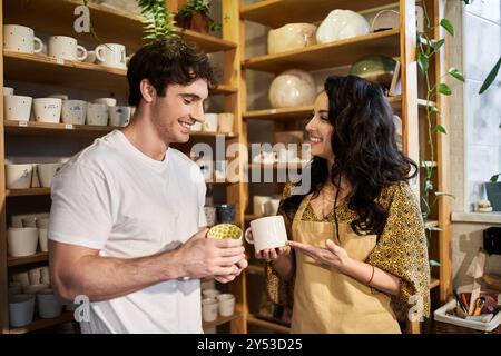 Ein fröhliches Paar bastelt Keramik, während es in einem hellen Studio lächelt. Stockfoto