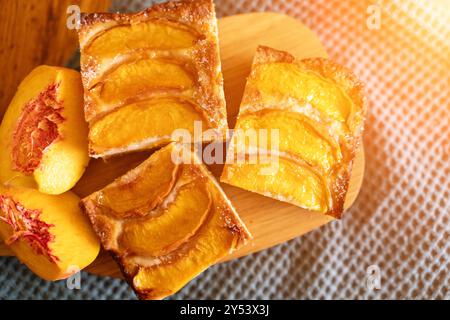 Ein Dessert aus geschnittenen Pfirsichen ist auf einem hölzernen Schneidebrett. Das Dessert ist mit Zucker bedeckt und sieht köstlich aus. Stockfoto