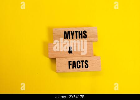 Mythen und Fakten Botschaft auf Holzblöcken mit gelbem Hintergrund. Begriffliches Mythen- und Tatsachensymbol. Kopierbereich. Stockfoto