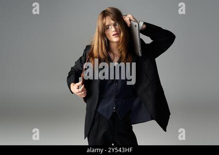 Ein junger Mann in modischer Kleidung zeigt eine dynamische Pose und zeigt einzigartigen Stil und Selbstvertrauen. Stockfoto