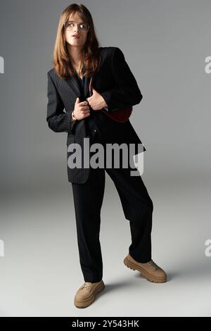 Ein junger Mann zeigt sein schickes Modegefühl und strahlt Vertrauen in ein stilvolles Outfit aus. Stockfoto