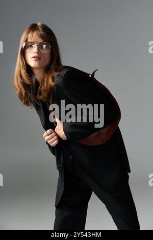 Mit einer trendigen Brille und einem schicken Outfit posiert ein junger Mann mit Flair. Stockfoto
