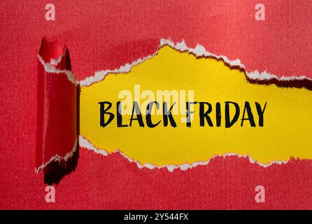 Schwarze freitag-Nachricht auf gerissenem rotem Papier mit gelbem Hintergrund. Schwarzes freitag-Symbol. Kopierbereich. Stockfoto