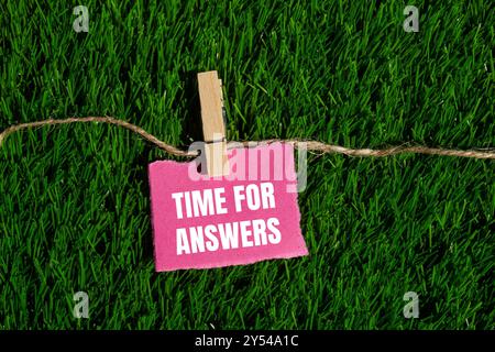 Zeit für Antworten Nachricht geschrieben auf gerissenem rosafarbenem Papierstück mit grünem Grashintergrund. Symbol für die konzeptionelle Zeit für Antworten. Kopierbereich. Stockfoto
