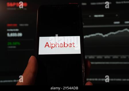 In dieser Fotoabbildung wird das Logo von Alphabet Inc. Auf einem Smartphone mit Hintergrund einer S&P-Index-Website angezeigt. Stockfoto