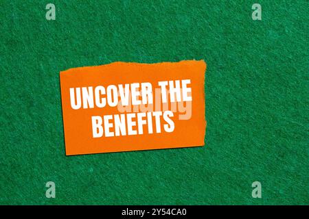 Decken Sie die Vorteile auf einem gerissenen orangefarbenen, gerissenen Papierstück auf grünem Hintergrund ab. Entdecken Sie das Symbol „Vorteile“. Kopierbereich. Stockfoto