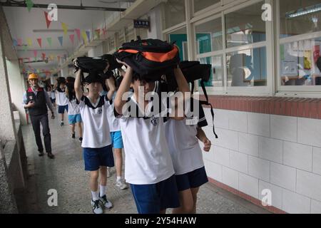 Schüler der Junior High School legten ihre Schultaschen auf den Kopf und gingen nach draußen, um an der jährlichen Erdbebenbohrung in Taipeh am 20. September 2024 teilzunehmen, um das Erdbeben 921 zu begehen. Taiwan wurde 1999 von einem Erdbeben der Stärke 7,2 erschüttert. Copyright: XJameson Wux Stockfoto