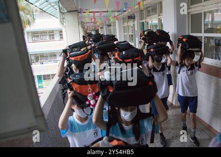 Schüler der Junior High School legten ihre Schultaschen auf den Kopf und gingen nach draußen, um an der jährlichen Erdbebenbohrung in Taipeh am 20. September 2024 teilzunehmen, um das Erdbeben 921 zu begehen. Taiwan wurde 1999 von einem Erdbeben der Stärke 7,2 erschüttert. Copyright: XJameson Wux Stockfoto
