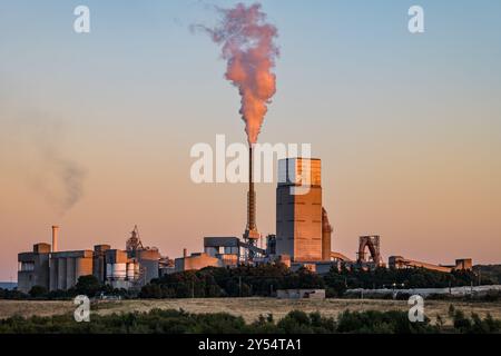 Dunbar Cement arbeitet an Industriebauten mit Wasserdampf, der bei Sonnenuntergang aus dem Schornsteinturm austritt, East Lothian, Schottland, Großbritannien Stockfoto