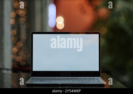Kaputter Laptop mit weißem Bildschirm auf dunklem Holztisch Stockfoto