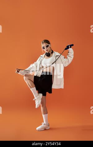 Eine lebendige Athletin drückt ihre Emotionen aus, während sie ein Sprungseil hält und selbstbewusst aussieht. Stockfoto