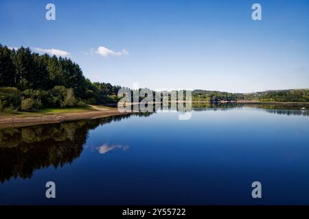 Blauer Himmel spiegelt sich im tiefblauen Wasser an einem ruhigen Sommertag im Wayoh Reservoir, Blackburn, Lancashire. Stockfoto