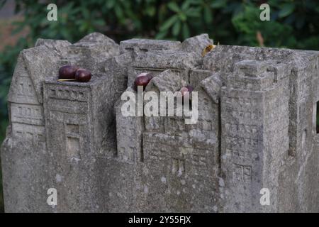 Grabstein mit geschnitzten Häusern und kleineren Häusern auf dem Grab, Alter St. Matthäus Kirchhof in Berlin. Stockfoto
