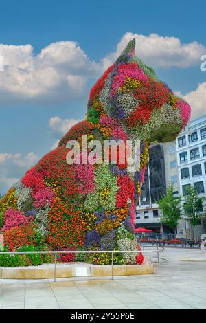 Menschen in der Nähe des Kunstwerks „Welpe“ mit Blumen in der Saison von Jeff Koons vor dem berühmten Guggenheim Museum im Zentrum von Bilbao, Baskenland Stockfoto