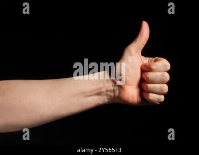 Daumen hoch Handgeste auf schwarzem Hintergrund Stockfoto