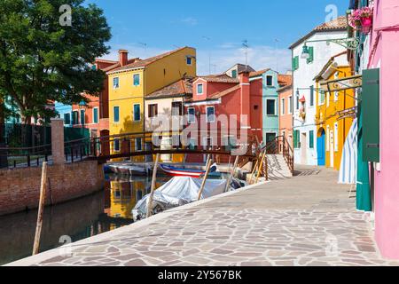 Bunte bunte Häuser in Venedig auf der Insel Burano. Schmaler Kanal mit Motorbooten entlang der Häuser. Sommersonntag. Selektiver Fokus. Stockfoto