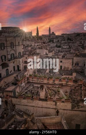 Ein weitläufiger Blick aus der Luft auf eine geschäftige Stadtlandschaft mit einem wunderschönen Sonnenuntergang, der den Horizont im Hintergrund beleuchtet Stockfoto