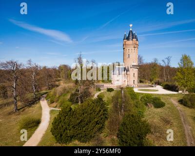 Blick aus der Vogelperspektive auf den historischen Flatow Tower, umgeben von üppigem Grün unter einem klaren blauen Himmel im Babelsberg Park in Potsdam, Deutschland - Kopierraum Stockfoto