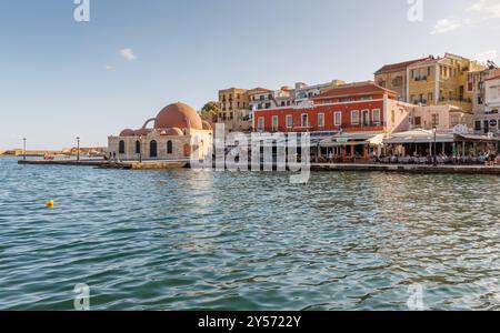 CHANIA, GRIECHENLAND – 11. SEPTEMBER: (HINWEIS DER REDAKTION: Für dieses Bild wurde ein Farbfilter mit Abstufung verwendet.) Besucher sitzen am 11. September 2024 in Chania, Griechenland, in Restaurants neben der Hasan-Pascha-Moschee im Hafen der Altstadt. Stockfoto