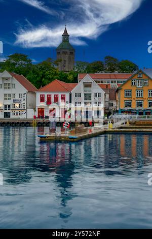 Eine wunderschöne ruhige Küstenszene mit farbenfrohen Häusern, die sich im ruhigen Wasser unter einem dramatischen Himmel spiegeln Stockfoto