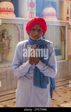 Puschkar, Rajasthan, Indien. November 2022. Mann in einem roten Turban betet in einem Hindutempel. Stockfoto