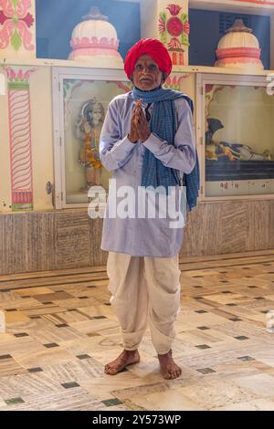 Puschkar, Rajasthan, Indien. November 2022. Mann in einem roten Turban betet in einem Hindutempel. Stockfoto