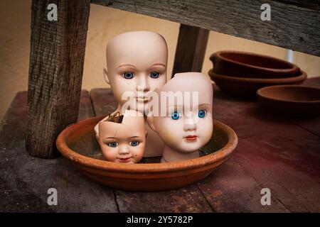 Drei Vintage-Porzellan-Puppen, jede mit atemberaubend schönen Details und gläsernen Augen, die Ihnen zu folgen scheinen, wecken ein Gefühl von Nostalgie. Stockfoto