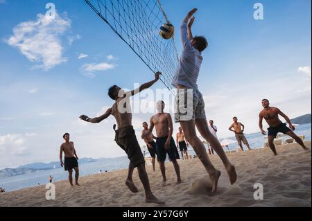 Teams mit multinationalen Spielern spielen im Sommer Beachvolleyball am Meer in Nha Trang in Asien. Nha Trang, Vietnam - 4. August 2024 Stockfoto