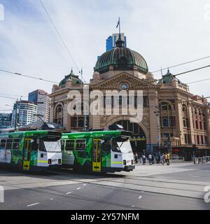 Melbourne, Australien - 10. Januar 2021: Zwei legendäre Straßenbahnen fahren auf der Swanston Street vor dem Bahnhof Flinders Street vorbei. Stockfoto