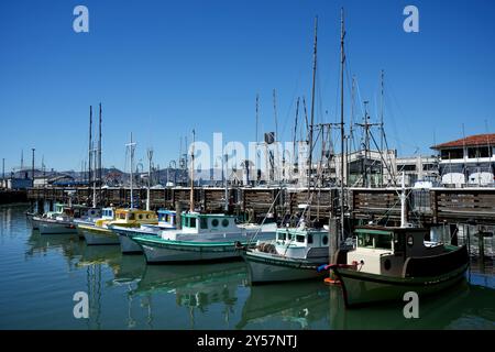 Vintage-Boote, die an Fisherman's Wharf unter blauem Himmel ankern. Stockfoto