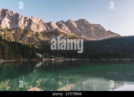 Eine Landschaft des Eibsees in Bayern, Süddeutschland. Das Wasser reflektiert das Ufer, den grünen Wald und die Berge der Alpen. Stockfoto