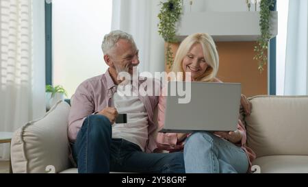 Glückliches älteres reifes kaukasisches Paar ältere reife alte Frau Ehemann männlich mit Kreditkarte erfolgreiche Fernzahlung Frau Mann Familiengespräch Stockfoto