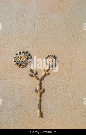 Blumen aus Kieselsteinen einer kleinen blau-weißen Kapelle in der Nähe von Malia auf Kreta, Griechenland Stockfoto