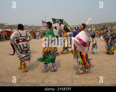 Einheimische amerikanische Jingle- und Ribbon-Tänzer bei einem Powwow in Lodgepole, Montana. Indianische Kinder in voller Insignien tanzen im Hintergrund. Stockfoto