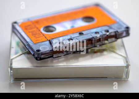 Nahaufnahme eines alten Musikkassettenbands und dessen Halterung in weiß isoliert. Stockfoto