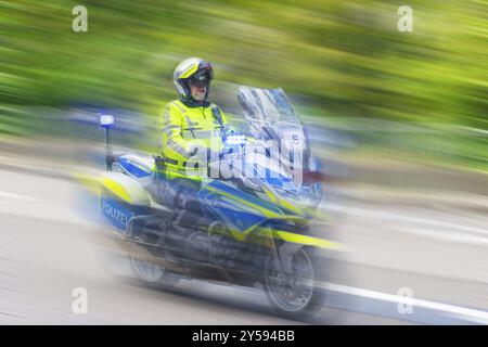 Polizist auf einem Motorrad, der schnell auf der Straße fährt, die Geschwindigkeit wird durch die Bewegungsunschärfe betont, Stuttgart, Baden-Württemberg, Deutschland, Europa Stockfoto