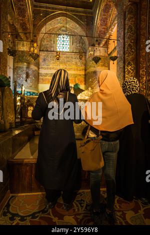 Konya, Türkei - 14. September 2021: Drei Frauen in traditionellen Hijabs stehen in einer wunderschön dekorierten historischen Moschee und heben die Kultur hervor Stockfoto