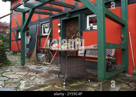 Rotes Fachwerkhaus, vorne mit Holztür und Bank bei Kerzenlicht bei Dämmerung Stockfoto