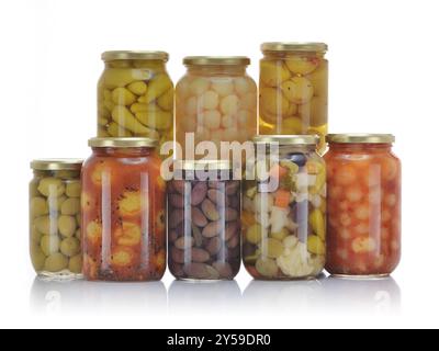 Eine Vielzahl eingelegter Gemüsesorten, einschließlich Oliven, Blumenkohl, Karotten und Paprika, in Gläsern mit goldenen Deckeln. Stockfoto
