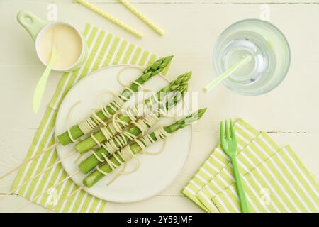 Gedämpfter grüner Spargel auf Holzspießen mit Spaghetti in Hollandaise-Sauce Stockfoto