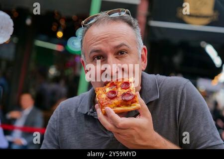 New York, New York, USA. September 2024. Das fest feiert das Leben des San Gennaro von Neapel, der Bischof von Benevento Italien war und 305 n. Chr. zum Märtyrer wurde. Das Little Italy Festival ist bekannt für italienische Gerichte wie Pizza, Würstchen, Cannolis, Zeppoles und vieles mehr. Alles Italienisch. Die berühmte Chefkochin Anne Burrell war der Grand Marshal. Beim Festmahl eine Scheibe essen. (Kreditbild: © Milo Hess/ZUMA Press Wire) NUR REDAKTIONELLE VERWENDUNG! Nicht für kommerzielle ZWECKE! Stockfoto