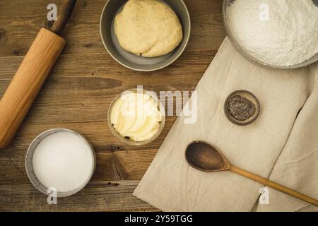 Sammlung von Zutaten und Utensilien zum Backen von veganen Keksen mit Margarine und Chia als Eierersatz auf dunklem Holzboden Stockfoto