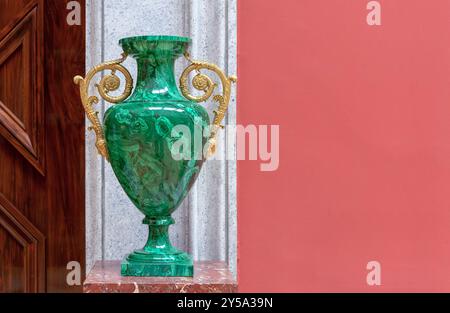 Grüne Malachitvase mit goldenen Griffen auf Marmorsockel. Stockfoto