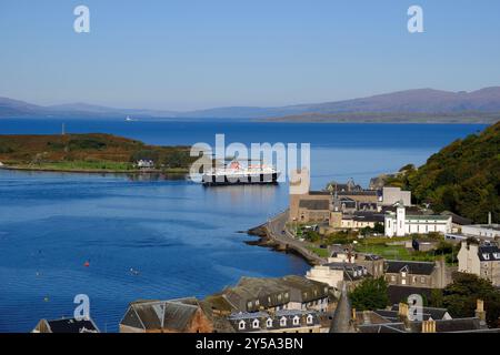 Oban, Schottland, Großbritannien. September 2024. Herrliches warmes und sonniges Wetter in Oban und an der Westküste mit Blick auf die Stadt und den Hafen und Blick auf die Berge von Mull. Die sonnigen Bedingungen werden voraussichtlich über das Wochenende andauern. Caledonian MacBrayne Fähre „Isle of Mull“, Abfahrt nach Craignure auf der Isle of Mull. Blick vom McCaig's Tower. Quelle: Craig Brown/Alamy Live News Stockfoto