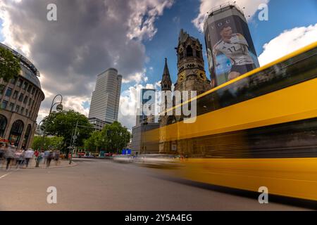 Berlin - 22. Juni 2024: Gelber Doppeldeckerbus mit Bewegungsunschärfe. Kaiser-Wilhelm-Gedächtniskirche, Kurfürstendamm. Langbelichtungsaufnahme. Sonntags Stockfoto