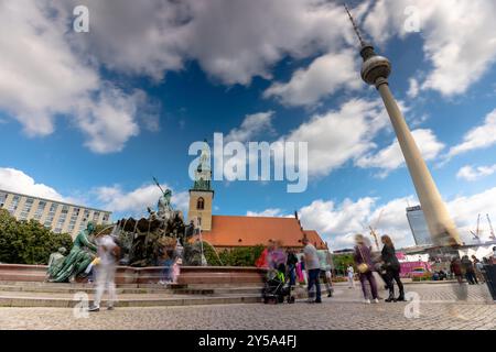 Berlin, 23. Juni 2024: Fonte de Neptuno, Berliner Fernsehturm. Zeitraffer. Sonniger Tag, mittelbewölkter Himmel. Stockfoto